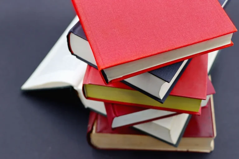 Stack of red and dark hardback books